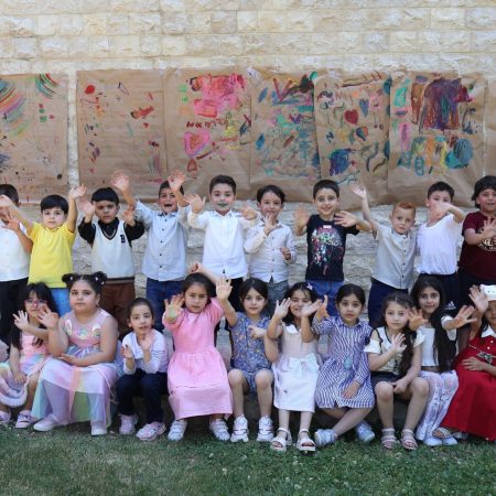 أطفال الروضات يودعون مدرستهم برسم لوحات الفرح